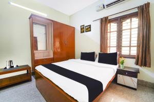 a bedroom with a large bed and a window at Hotel O Singanallur Coimbatore in Coimbatore