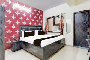 加济阿巴德Super Hotel O Nehru Nagar Near Bus Stand的一间卧室设有一张床和红色的墙壁