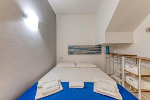 a small bedroom with a bed and a staircase at Villetta Alma Maldive Del Salento in Marina di Pescoluse