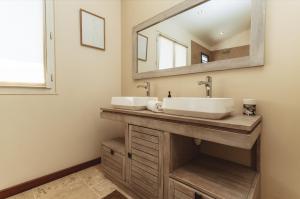 a bathroom with two sinks and a mirror at Maison Makoa et sa piscine proche du front de mer in Saint-Pierre +12 photos