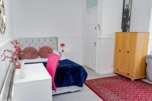 a bedroom with a bed and a red rug at Spacious and Comfy Pad - Perfect for Long Stays & Contractors - Close to Sports Village, Leigh Market, and Mesnes Park - Easy Parking - Speedy Wi-Fi - Free On-Site or Nearby Parking - Private Luxury Garden in Leigh +25 photos