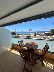 Ein Tisch und Stühle auf einem Balkon mit Blick auf das Meer in der Unterkunft Dimitri Hotel in Himarë
