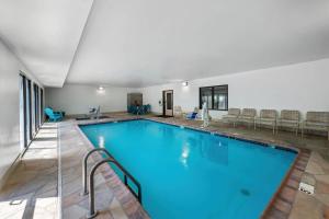 a large swimming pool with blue water in a building at Quality Inn & Suites Manhattan in Manhattan