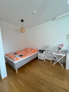 a bedroom with a bed and a desk and a chair at Studio next to Sello and Leppävaara train station in Espoo