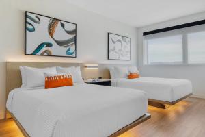 two white beds in a room with a window at Cambria Hotel Burbank Airport in Burbank +83 photos