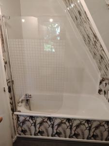 bagno con doccia e vasca con porta in vetro di Chalet pleine nature 8mn de Vendôme a Renay