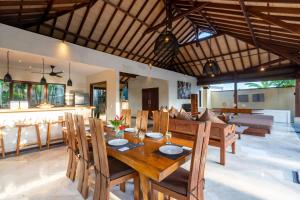 a dining room and living room with a table and chairs at Villa Alroda Antik - Peaceful 4BR Villa with Private Pool in Canggu in Dalung