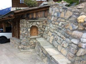 a stone building with a door and a stone wall at Appartement à Courchevel Saint Bon in Saint-Bon-Tarentaise
