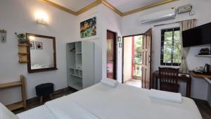 a bedroom with a large white bed and a window at LaligurasVilla Beachside Escape - 100m to Beach in Candolim +114 photos