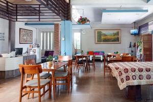 Un restaurante con mesas y sillas de madera y un mostrador. en Sans Hotel Grand Jitra Syariah Bengkulu, en Bengkulu