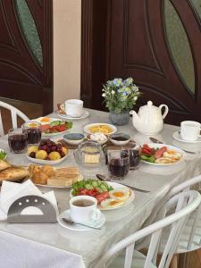 a table with plates of food and cups of coffee at Anor Avenue Hotel in Tashkent