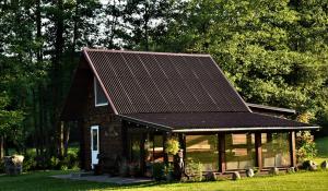 a house with a metal roof on top of it at Sodyba LAIMĖS SLĖNIS in Kapčiamiestis