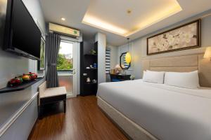 a bedroom with a large white bed and a television at Golden Amour Hotel in Hanoi