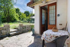 Una mesa frente a una puerta con una canasta encima. en Appartamento immerso nel verde, en Lanzo d'Intelvi 13 fotos más
