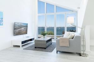 - un salon avec un canapé, une chaise et une grande fenêtre dans l'établissement Strandweg 6-7 Sandhalm, à Möltenort