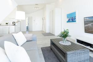 un salon avec un canapé et une table dans l'établissement Strandweg 6-7 Sandhalm, à Möltenort 42 autres photos