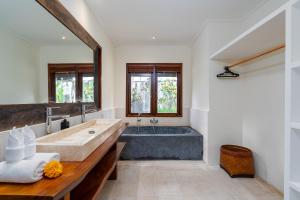 a bathroom with a large tub and a sink at Villa Alroda Antik - Peaceful 4BR Villa with Private Pool in Canggu in Dalung