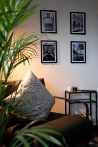 Una sala de estar con un sofá y cuadros en la pared. en Black & White Apartment - Balkon, Netflix, Nespresso, Zentral, Messe, en Chemnitz