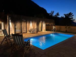 una piscina por la noche con sillas y una mesa en Berceste Villas, en Akyaka 18 fotos más