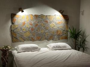 1 cama con 2 almohadas y un mapa en la pared en Berceste Villas, en Akyaka
