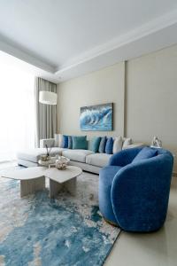 a living room with a blue couch and a table at Nasma Luxury Stays - Calming Blues Stylish 1BR in Hayat Island in Ras al Khaimah
