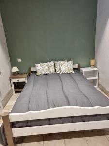 a large bed in a bedroom with two night stands at Les Antiers in Saint-Georges-dʼElle