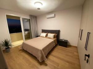 a bedroom with a bed and a large window at Limassol Marina Seaview Suite in Limassol