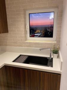 a kitchen with a sink with a tv above it at Limassol Marina Seaview Suite in Limassol