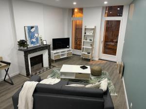 a living room with a couch and a fireplace at Les Apparts de la Bastide 35A in Villeneuve-sur-Lot