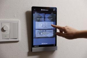 福岡市にある博多の旅籠 すノやの壁に掛けられた携帯電話を指差す手