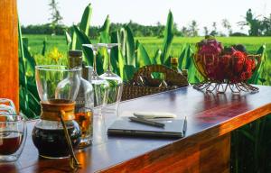 a wooden table with wine glasses and flowers on it at Coconut Corner - Rice Field Dome in Tanah Lot