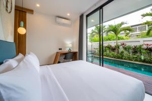 a bedroom with a large bed and a swimming pool at Sunny Village Berawa in Canggu