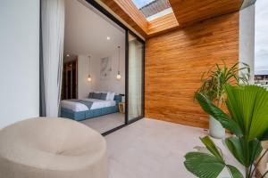 a room with a bed and a couch on a balcony at Sunny Village Berawa in Canggu
