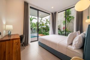 a bedroom with a bed and a desk and a window at Sunny Village Berawa in Canggu +37 photos