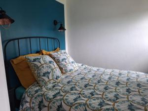 a bed with a comforter and pillows in a bedroom at La petite maison normande in Honfleur +2 photos