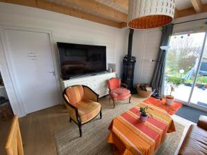 a living room with a television and a table and chairs at Villa Thorens in Morlaix