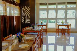 a dining room with tables and chairs and windows at Andaman Beach Resort in Shādipur