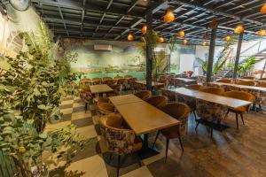 a restaurant with tables and chairs and plants at Chandrika Green Resort in Vrindāvan