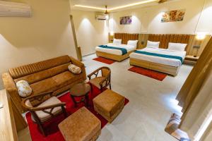 a hotel room with two beds and a couch at Chandrika Green Resort in Vrindāvan