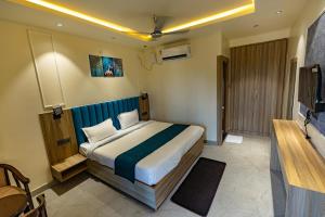 a bedroom with a bed and a television in it at Chandrika Green Resort in Vrindāvan