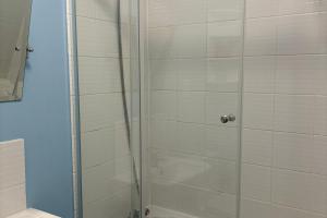 a shower with a glass door in a bathroom at Seafront Sheringham 1 bed Apt sleeps 4 - 1xdog in Sheringham +7 photos