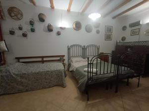 sypialnia z dwoma łóżkami i płytami na ścianie w obiekcie Alessi Suites & Studio w mieście Mazzarino +37 zdjęć