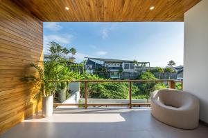 a room with a large window with a chair on a balcony at Sunny Village Berawa in Canggu