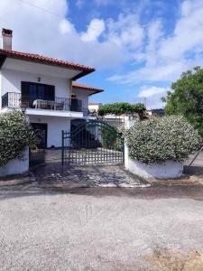 a white house with a fence in front of it at Villa Nefeli in Ayios Nikolaos Sithonia