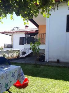 a house with a table in front of a yard at Villa Nefeli in Ayios Nikolaos Sithonia