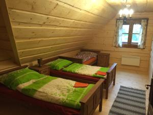 a room with two beds in a log cabin at Drevenica Vanesa in Terchová