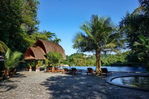 un resort con piscina, sedie e palma di SanGria Resort And Spa a Lembang