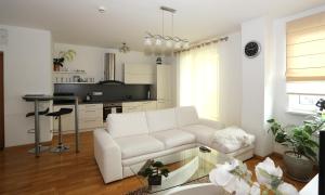 a living room with a white couch and a table at Apartamentai Panevezys in Panevėžys