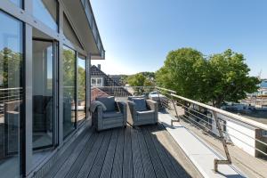 a balcony with two chairs on a house at Strandweg 6-7 Strandhafer in Möltenort