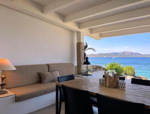 una sala de estar con una mesa y un sofá en House On The Sea Porto Rotondo, en Porto Rotondo